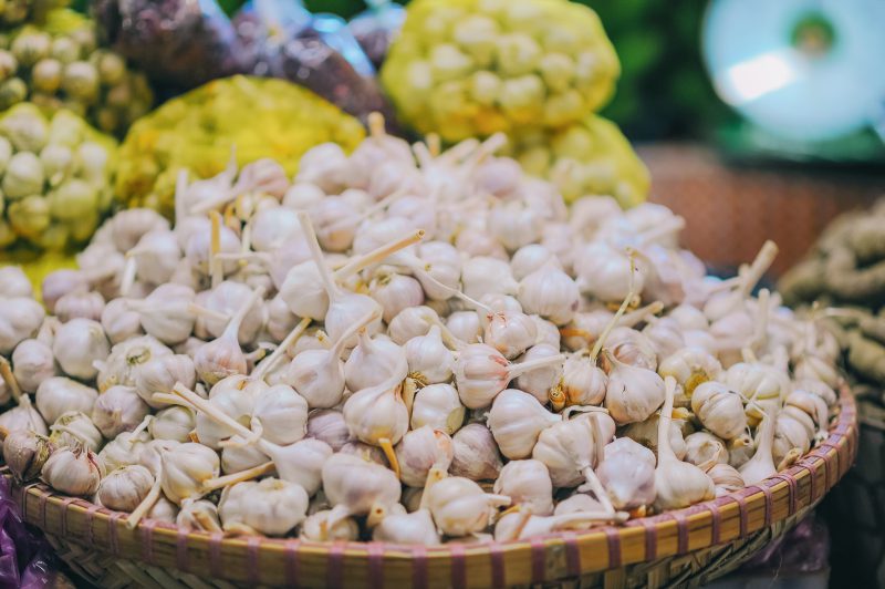 Selective focus photography of pile of garlic bulbs