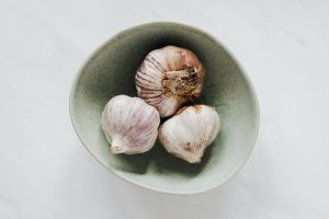 Bowl of garlic bulbs on marble table
